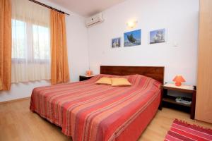 - une chambre avec un grand lit et une couverture rouge dans l'établissement Apartments and rooms with parking space Brsecine, Dubrovnik - 8541, à Zaton