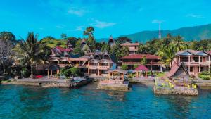 ein Resort auf dem Wasser mit Bergen im Hintergrund in der Unterkunft Lekjon Cottage in Tuk Tuk