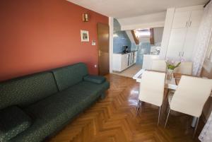 - un salon avec un canapé vert et une table dans l'établissement Apartment Kukljica 8253d, à Kukljica