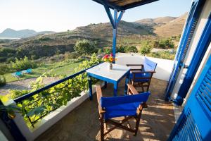 a table and chairs on the balcony of a house at Sunset Hotel in Agios Ioannis Kaspaka