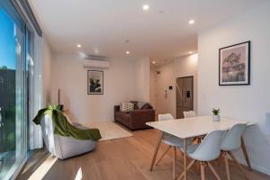 a dining room and living room with a table and chairs at Malthouse Lane City Apartment 2 in Nelson