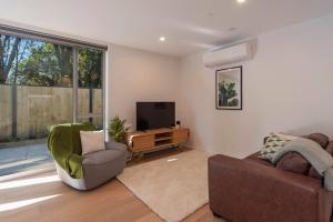 a living room with a couch and a television at Malthouse Lane City Apartment 2 in Nelson