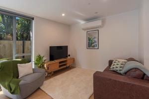 a living room with a couch and a television at Malthouse Lane City Apartment 2 in Nelson