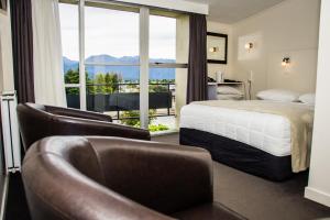 ein Hotelzimmer mit einem Bett und einem Balkon in der Unterkunft Fiordland Hotel in Te Anau