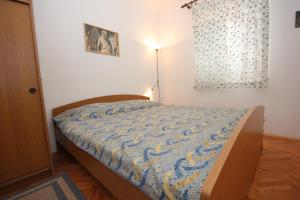 a bedroom with a bed with a blue comforter at Apartments by the sea Sali, Dugi otok - 8194 in Sali