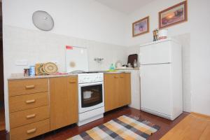 a kitchen with a white refrigerator and wooden cabinets at Apartments by the sea Sali, Dugi otok - 8194 in Sali