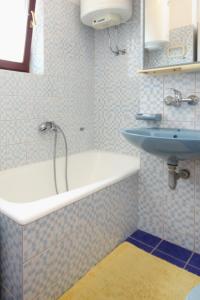 a bathroom with a bath tub and a sink at Apartments by the sea Sali, Dugi otok - 8193 in Sali