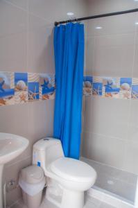 baño con aseo y cortina de ducha azul en Roxi's Place, en San Andrés
