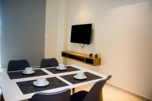 a dining room table with chairs and a flat screen tv at Apartamento en Sognare in Encarnación