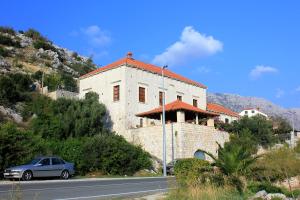 a car parked in front of a building on the side of a road at Seaside house with a swimming pool Mokosica, Dubrovnik - 8583 in Mokošica