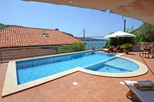 a large swimming pool sitting next to a house at Seaside house with a swimming pool Mokosica, Dubrovnik - 8583 in Mokošica