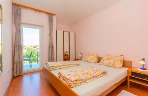 a bedroom with a bed and a large window at Apartments 4 Palme in Funtana