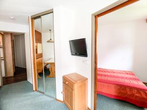 1 dormitorio con 1 cama y TV en la pared en Appartement Tignes, 2 pièces, 6 personnes - FR-1-502-401, en Tignes