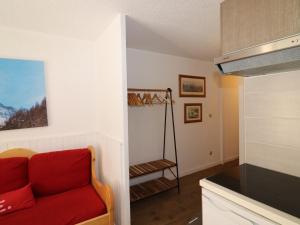 uma sala de estar com um sofá vermelho e uma cozinha em Studio Tignes, 1 pièce, 5 personnes - FR-1-502-415 em Tignes
