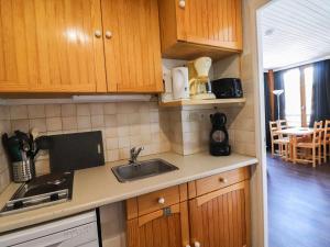 a kitchen with wooden cabinets and a sink at Studio Tignes, 1 pièce, 4 personnes - FR-1-502-417 in Tignes