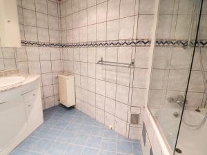 a white tiled bathroom with a shower and a sink at Studio Tignes, 1 pièce, 4 personnes - FR-1-502-417 in Tignes