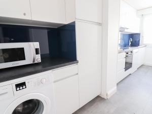 Biała kuchnia z pralką i kuchenką mikrofalową w obiekcie Appartement skis aux pieds, balcon, 6 pers, Tignes Le Lac - FR-1-502-405 w mieście Tignes