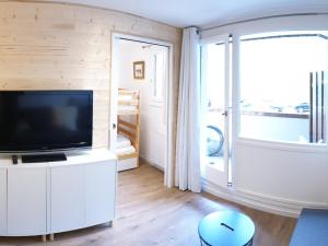 Televízia a/alebo spoločenská miestnosť v ubytovaní Studio rénové avec balcon, au pied des pistes, proche commerces et écoles de ski - FR-1-502-435