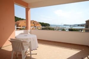 einen weißen Tisch und Stühle auf einem Balkon mit Aussicht in der Unterkunft Apartments by the sea Kukljica, Ugljan - 8451 in Kukljica