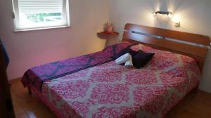 a bedroom with a bed with a red and purple comforter at Apartments by the sea Luka, Dugi otok - 8182 in Luka