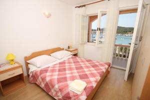 sypialnia z łóżkiem i dużym oknem w obiekcie Apartments by the sea Kukljica, Ugljan - 8316 w mieście Kukljica