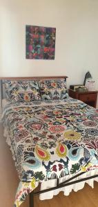 Una cama con un edredón colorido en un dormitorio en Lola's Guest House, en Mactan
