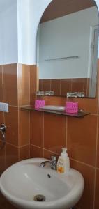 a bathroom with a sink and a mirror and a mirror at Lola's Guest House in Mactan