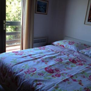 a bed with a floral comforter and a window at Apartments by the sea Molunat, Dubrovnik - 8550 in Molunat