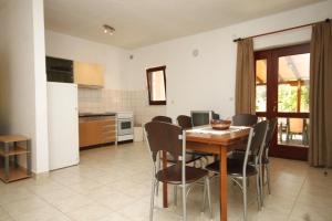 a kitchen and dining room with a table and chairs at Apartments by the sea Tkon, Pasman - 8376 in Tkon