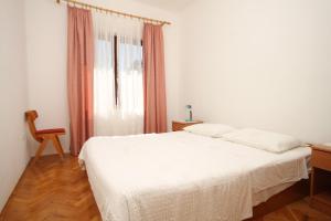 a bedroom with a white bed and a window at Apartments with a parking space Ugljan - 8403 in Ugljan