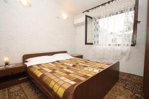 a bedroom with a large bed with a window at Apartments with a parking space Zdrelac, Pasman - 8514 in Ždrelac