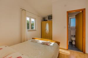 a bedroom with a bed and a bathroom with a toilet at Apartments by the sea Tkon, Pasman - 8455 in Tkon