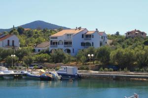 a house and boats docked in the water next to a river at Apartment Lukoran 8397b in Lukoran