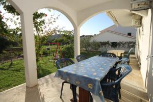 a patio with a table and chairs on a porch at Apartments by the sea Mrljane, Pasman - 8463 in Neviđane