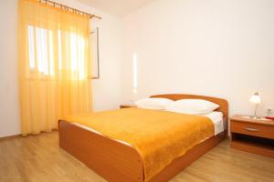 a bedroom with a large bed with a yellow blanket at Apartments by the sea Mrljane, Pasman - 8463 in Neviđane