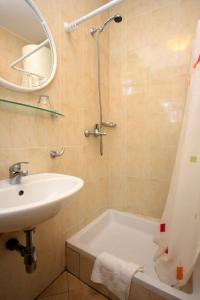 a bathroom with a sink and a tub and a shower at Apartments with WiFi Dubrovnik - 8590 in Dubrovnik