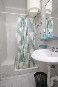 La salle de bains est pourvue d'un lavabo et d'un rideau de douche. dans l'établissement Apartments and rooms by the sea Mrljane, Pasman - 8464, à Neviđane