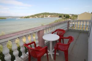 d'une table et de deux chaises sur un balcon avec vue sur la plage. dans l'établissement Apartments and rooms by the sea Mrljane, Pasman - 8464, à Neviđane