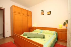 a bedroom with a bed and a large wooden cabinet at Apartments with a parking space Mrljane, Pasman - 8498 in Mali Pašman