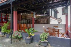 patio ze stołem, krzesłami i roślinami w obiekcie Urbanview Hotel Bergas Indah Bandungan by RedDoorz w mieście Bandungan