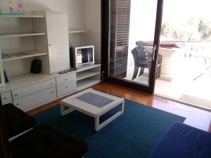a living room with a couch and a tv and a table at Apartments by the sea Lukoran (Ugljan) - 8494 in Lukoran