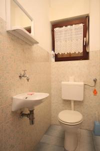 uma casa de banho com um WC e um lavatório em Apartments with a parking space Ugljan - 8493 em Ugljan