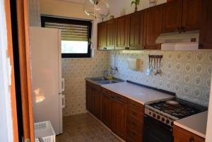 uma cozinha com armários de madeira e um forno com placa de fogão em Apartments with a parking space Ugljan - 8493 em Ugljan