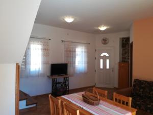 ein Wohnzimmer mit einem Tisch und einem TV in der Unterkunft Apartment Kukljica 8209a in Kukljica