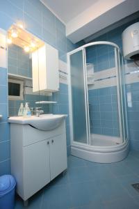 ein blaues Bad mit einem Waschbecken und einer Dusche in der Unterkunft Apartments by the sea Kukljica, Ugljan - 8209 in Kukljica