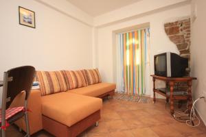 ein Wohnzimmer mit einem Sofa und einem TV in der Unterkunft Apartments by the sea Kukljica, Ugljan - 8209 in Kukljica