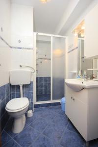 a bathroom with a toilet and a sink and a shower at Apartments by the sea Kukljica, Ugljan - 8209 in Kukljica