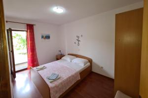 a small bedroom with a bed and a window at Apartments by the sea Dobropoljana, Pasman - 8198 in Dobropoljana