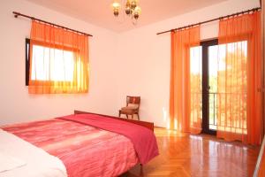1 dormitorio con 1 cama, 1 silla y ventanas en Apartments by the sea Ugljan - 8257 en Ugljan