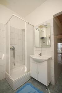 y baño blanco con lavabo y ducha. en Apartments by the sea Ugljan - 8257 en Ugljan